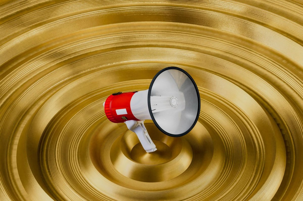 Arts News and Trending Topics. A red and white megaphone floats above a loudspeaker, conveying the message of arts news and arts sector headlines being announced.