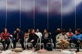 Diverse group of people seated and chatting against dark blue background. Conferences. Audience. Arts conference
