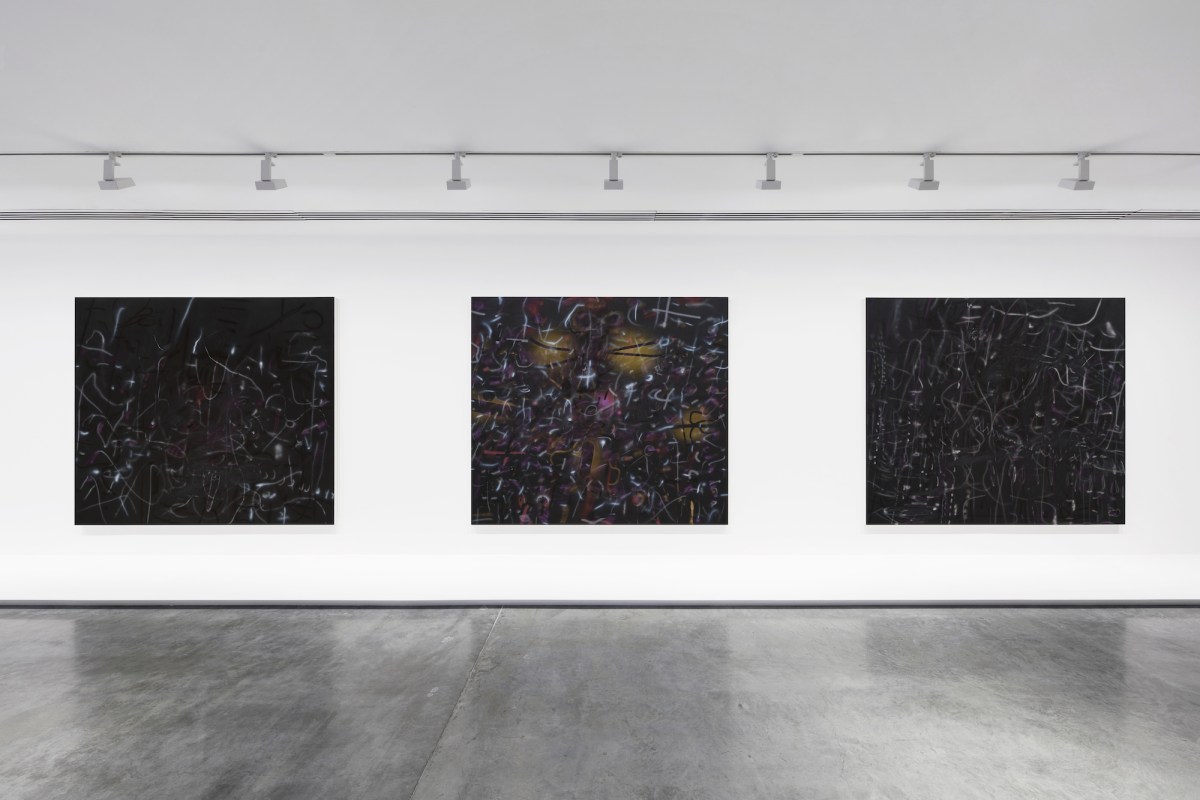 Three black abstract paintings in a gallery setting. Julie Mehretu