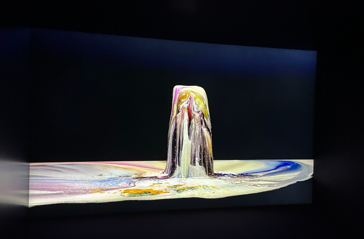 Video still of a melting block of ice with colour pigment in darkened room. Dawn Ng