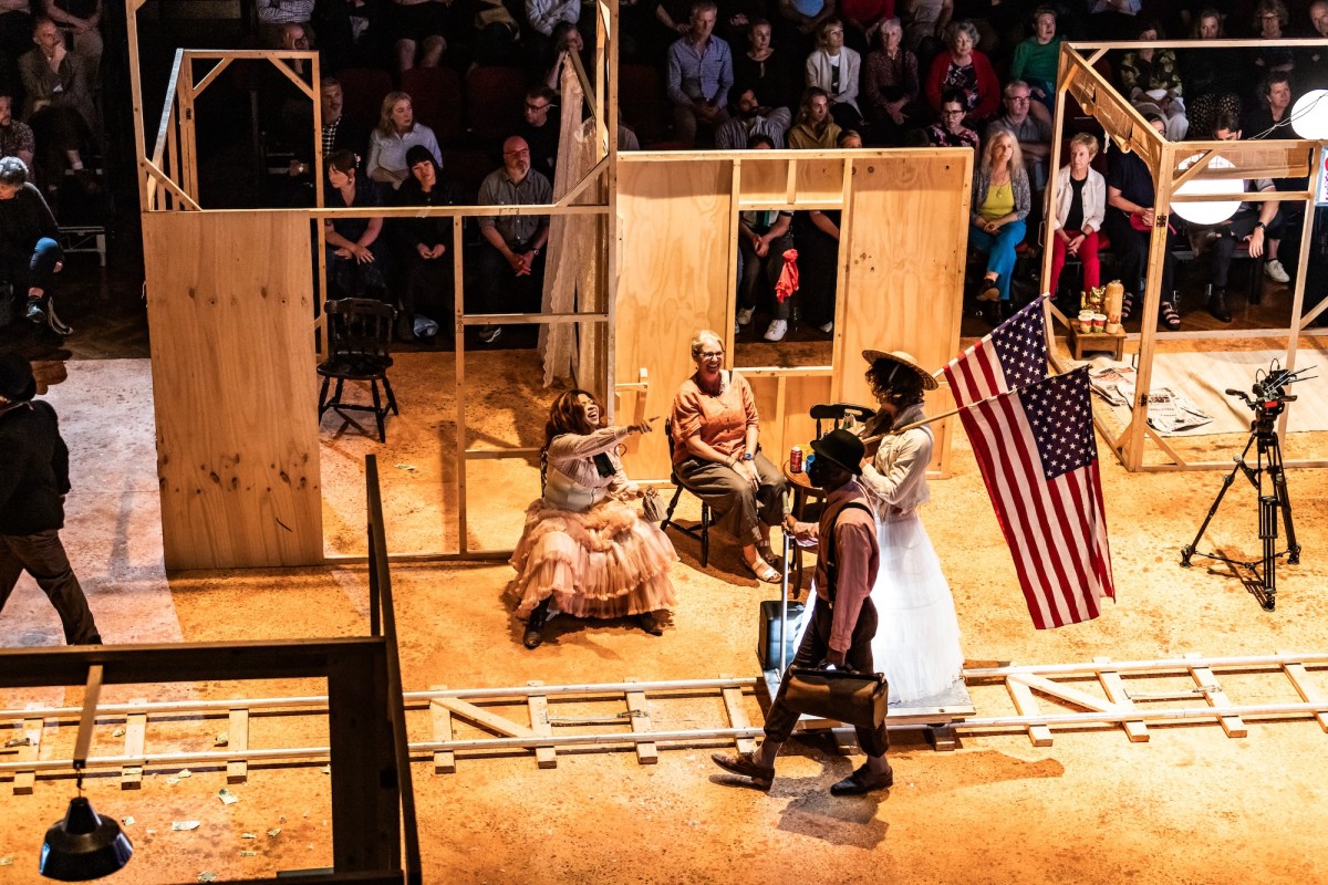 Actors on stage in colonial dress with American flag. Dark Noon.