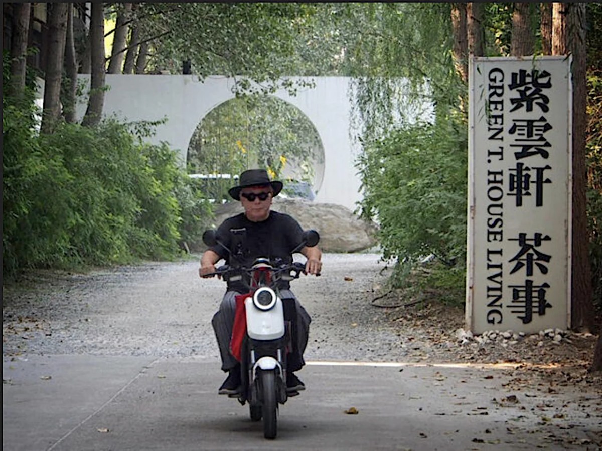 Man dressed in black with black hat on motor scooter in China. Laurens Tan