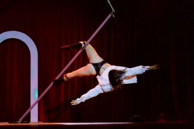 GRIT Productions' 'BITE' at The Garden of Unearthly Delights, Adelaide Fringe. A sex positive circus-burlesque-cabaret. The phto depicts a female-identitying performer pol-dancing, but the pole is untethered and the performer is using circus skills as as pole-dancing skills to create the scene.