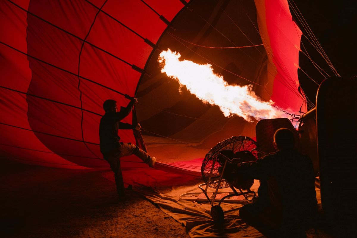 On The Move is ArtsHub's weekly round-up of Australian arts sector appointments from around the country. The photo depicts a hot air balloon being prepared for flight. Taken before dawn, the focus of the photo is the gas jet of flame generatng the heat required to inflate and fly the balloon.
