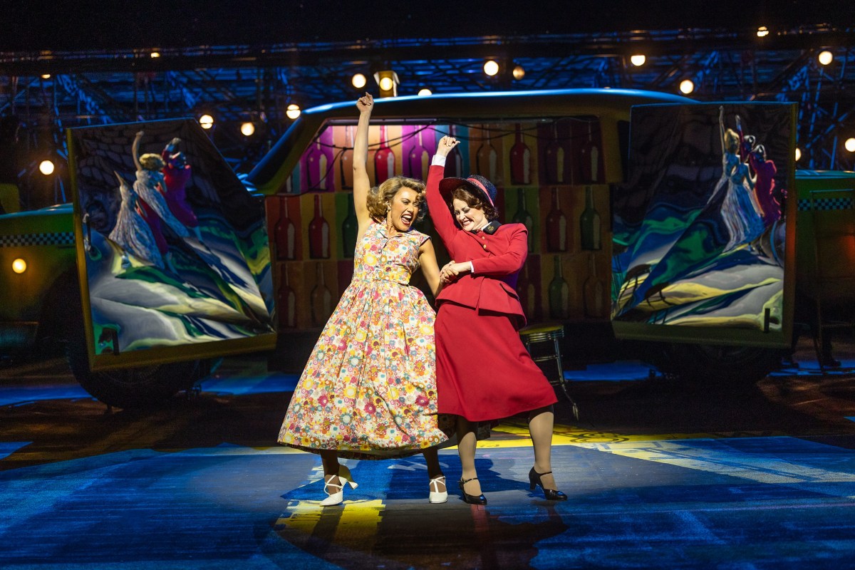 Two women in 1950s clothing signing on stage. Guys and Dolls