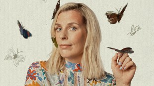 A Caucasian woman with shoulder length blonde hair and a flower pattern blouse has a butterfly on her raised hand and three more flying around her head. Sara Pascoe. I Am A Strange Gloop