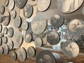 Paintings of skulls on discs set against a wall.