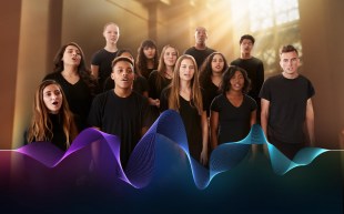 A choir of young performers. There is a way design in front of them.