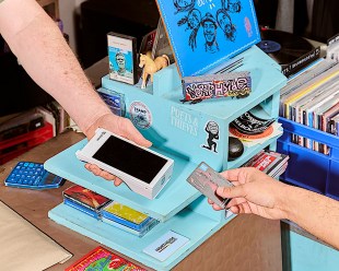 Someone buying purchasing in bookstore using point of sale machine. ArtsPay