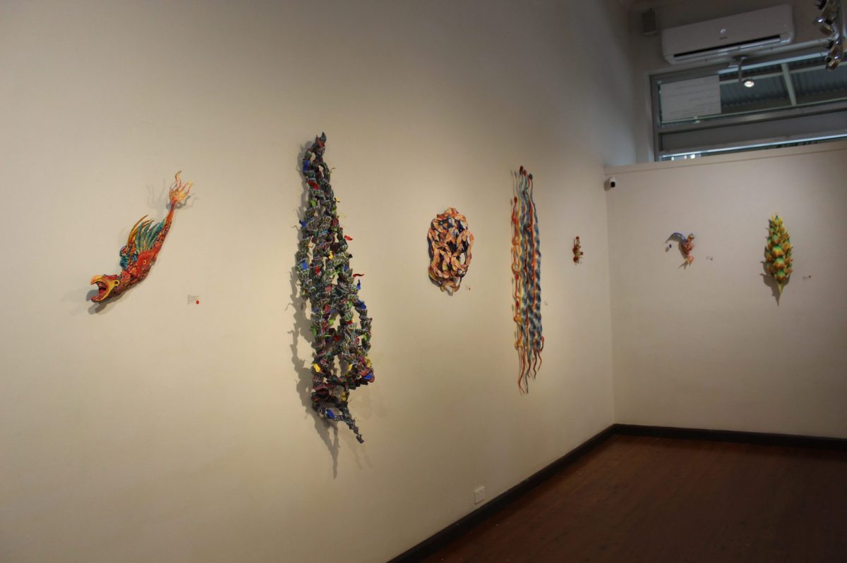 A range of colourful sculptures are affixed on the wall.