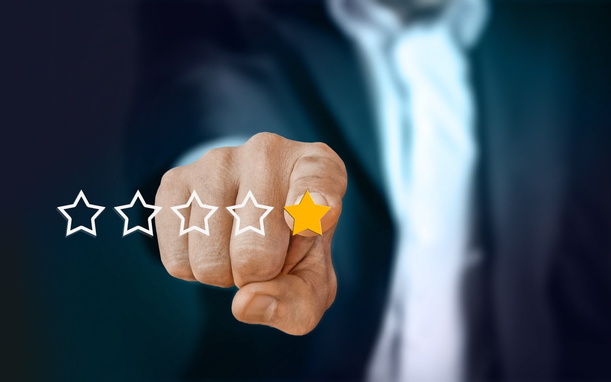 A man's torso with a finger pointing towards the camera and one out of five stars on the screen.