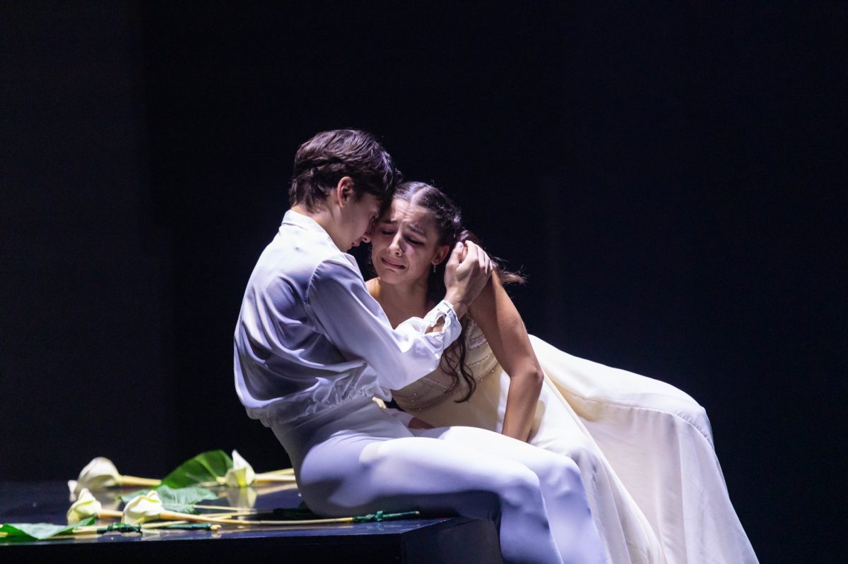 Two ballet dancers in white: a young man cradling a crying woman. Romeo and Juliet. Ballet International Gala