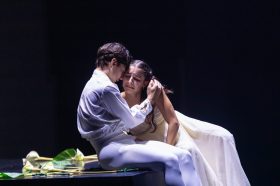 Two ballet dancers in white: a young man cradling a crying woman. Romeo and Juliet. Ballet International Gala