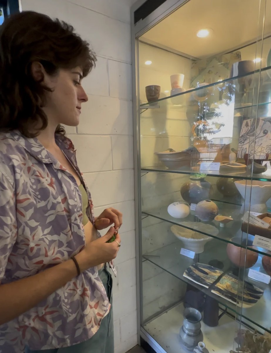 young woman looking at display of ceramics. Baylee Griffin.