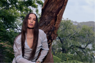 Transdisciplinary woman with long hair in landscape with trees. Bhenji Ra. Biennale Sydney