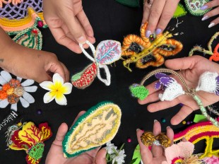 overhead image of hands holding hand made textile objects. Cul Collective.