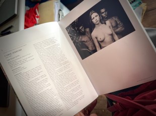 page open on book with art photo in black and white of a woman bare breast.
