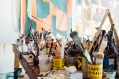 Artist table in studio covered with paintbrushes. Money tips for artists