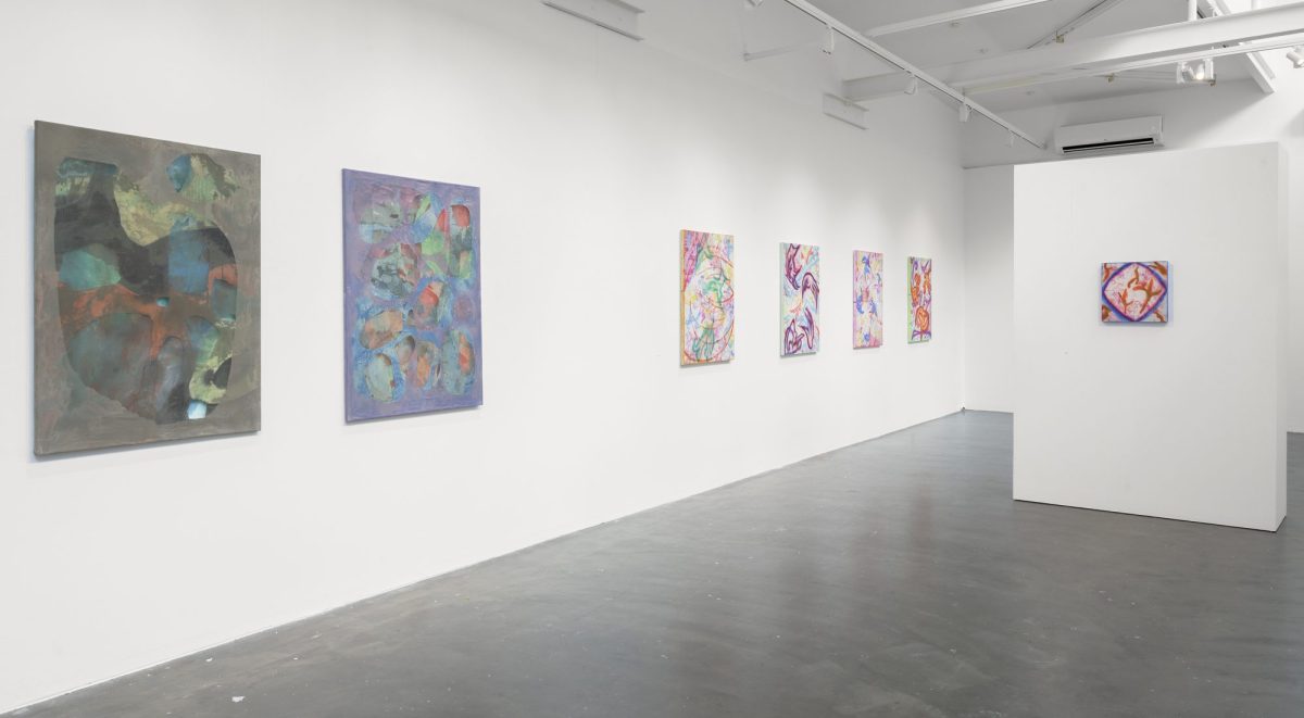 Abstract paintings hanging on a white wall.