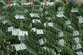Stacked empty green chairs. Event cancellations