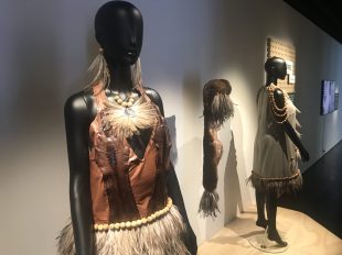 Two mannequins wearing Indigenous designs.