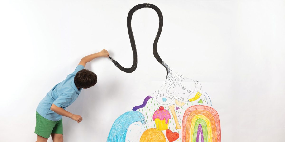 Child paints on white wall.