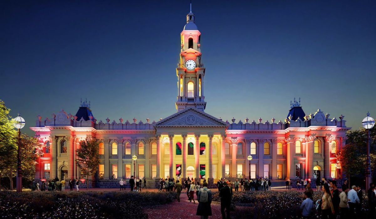 South Melbourne Town Hall in happier days. Formerly the home of ANAM, the building has been closed since 2020. The photo shows a brightly lit Victoria-era edifice at dusk, including its dominant central clock tower.