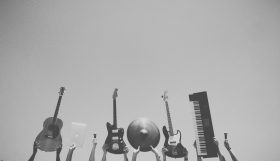 Musicians holding instruments into the sky.