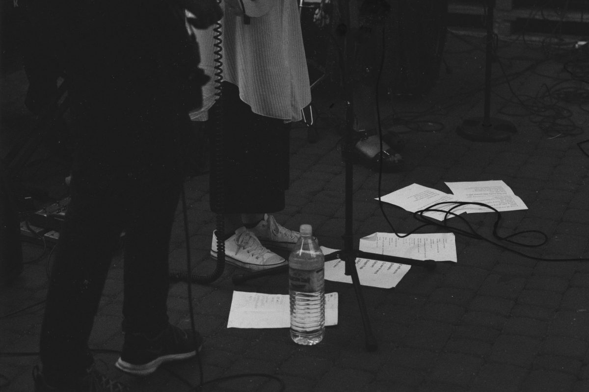 Singer's and musician's feet standing in front of sheet music and microphones.