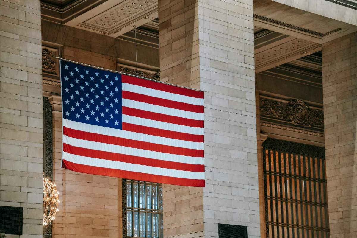 US arts policy change: an American flag flying in front of a stately building.