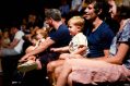 Kids and families sitting in an audience watching a show.