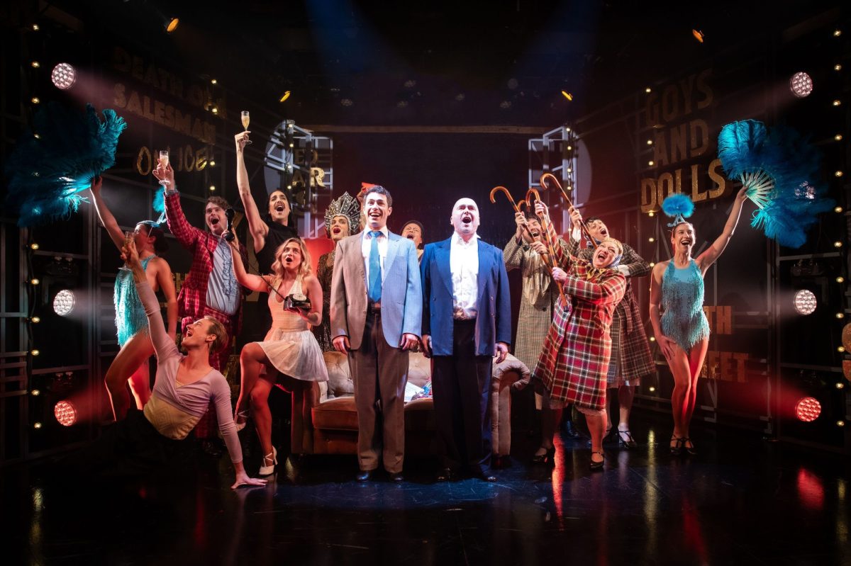 Full cast of 'The Producers.' A crowd is assembled around two men.