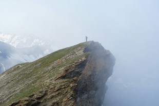 hiker on top of mountain in foggy environment. Visual artists and arts workers