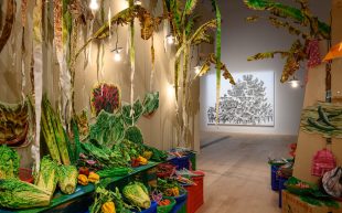 A colour installation that appears to resemble a meat and vegetable stall made with paper or cardboard. Museums to travel.