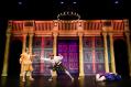 Three men in Elizabethan style costume against and elaborate backdrop. Two are fighting and the third is lying on the ground.