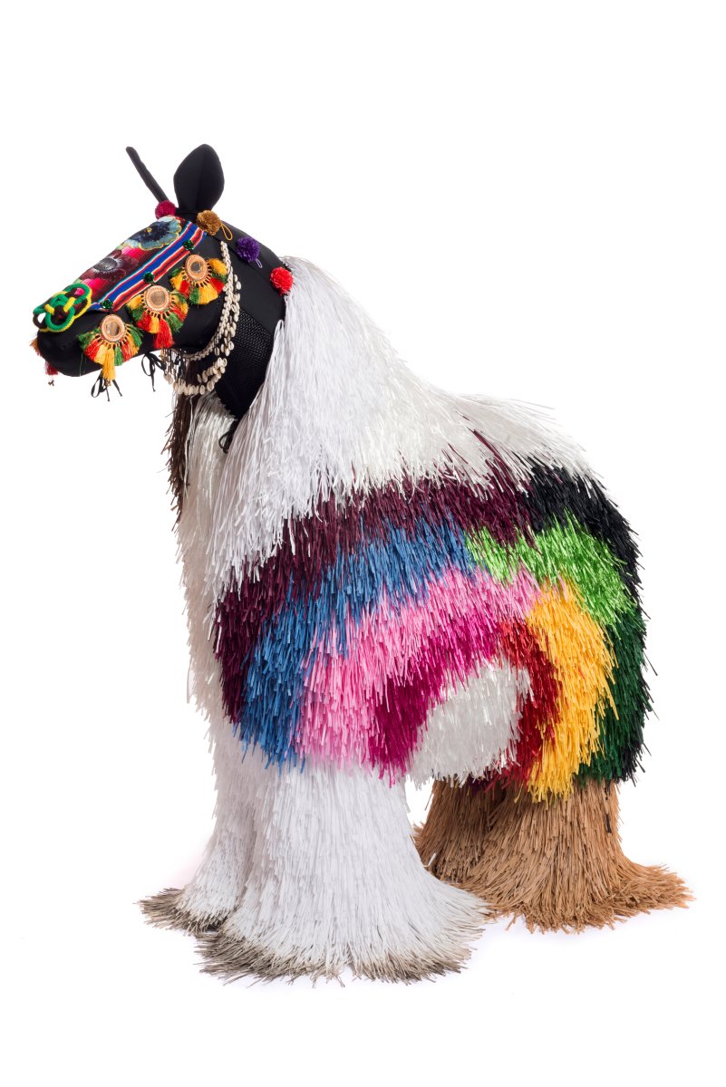 A horse-shaped wearable sculpture with colourful ornaments. Part of Brisbane Gallery of Modern Art Collecton.