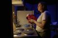 A woman standing at a stove. She's holding onto a red oven mitt. A scene from in Mi Todo Productions' 'Mary Jane' at The Old Fitz Theatre, 2025.