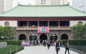 Visitors exiting a traditional Japanese building in Tokyo with Art Week Tokyo banners. Art travel guide.