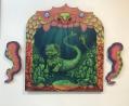 A Chinese lion, transformed into some form of mermaid, is framed like an old-fashioned theatre stage. The pieces on either side, completing the three-panel work, are octopus tentacles. The artwork by Ruby Li is showing as part of the Asian Heritage Week Exhibition at Dark Horse Experiment.