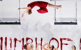 A performer in a red dress thrown in mid-air while a group of men wait to catch her. The Circa production travels to Edinburgh International Festival later this year.