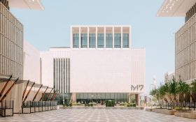 A photo of a white cube-like building in sunny daylight.