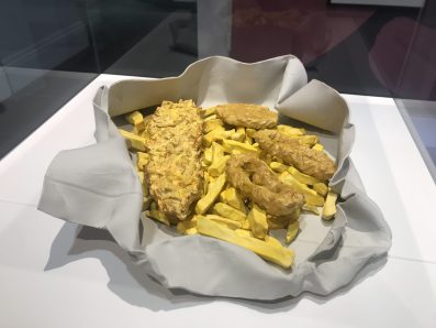 A large sculpture of fish and chips in white paper wrapping.