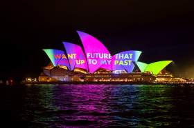 Vivid LIVE: The Sydney Opera House lit up at night by a rainbow coloured light projection with the text, 'I want my future to live up to my past' centred within the colourful composition.