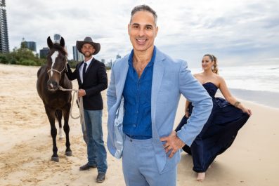 Under Michael Zavros' curatorial eye, BLEACH* Festival arrives at the Gold Coast later this year. Three people and a horse stand on a Gold Coast beach, smiling at the camera.