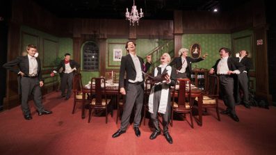 Seven men in formal dress in a dining room.