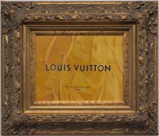 A painting enclosed within an elaborate gold frame with words 'Louis Vuitton' depicted in the artworks' centre. Showing as part of the exhibition 'Tracey Jones: Cultural Baggage' at CBD Gallery, Sydney.