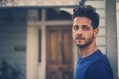 A photo of Lior, who will be at the Adelaide Guitar Festival. He is a young man with olive skin and dark, curly hair. He wears a blue t-shirt.