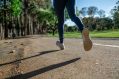 A photograph of a woman running, tajen from a low angle, with the focus being on her shoes and legs.