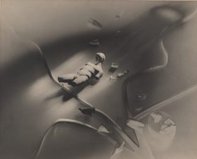 A black and white Surrealist photograph by Australian artist Max Dupain, which includes a small, broken statue and strange curving lines.