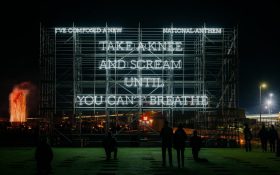 A large outdoor installation showing the words in white neon capitals ‘I’VE CREATED A NEW NATIONAL ANTHEM | TAKE A KNEE AND SCREAM UNTIL YOU CAN’T BREATHE”.